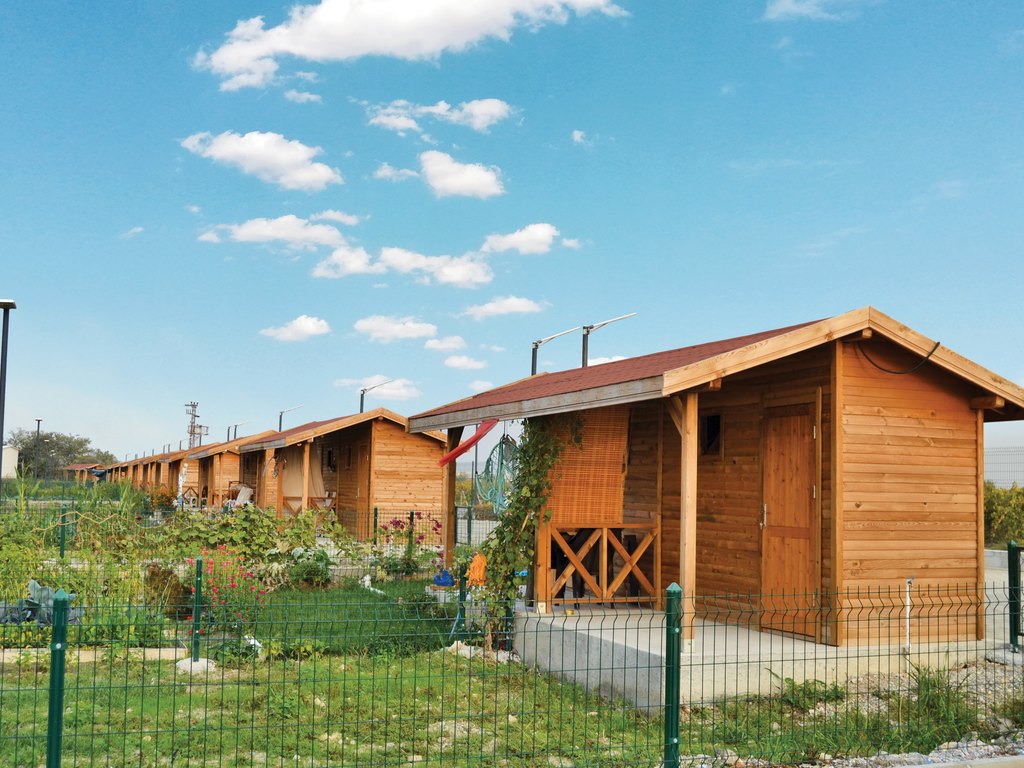 A row of small wooden hobby-garden cabins